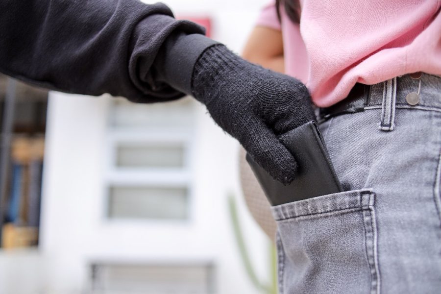 Close Up Of Gloved Hand Stealing Wallet From Someone's Back Pocket